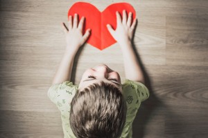Kid Laying on a Heart Paper