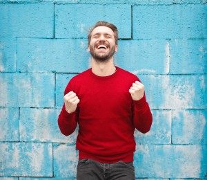 Man laughing on a blue wall