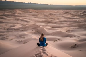 Woman Sitting on Sand Dunes
