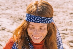 A woman laughing on the beach with red hair