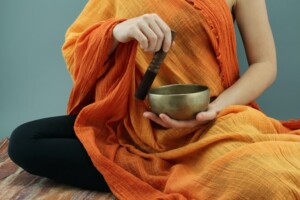 Person Making Sound with a Tibetan Bowl