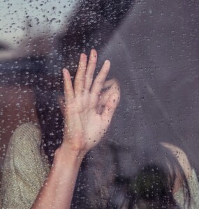 Woman Leaning on Rainy Window