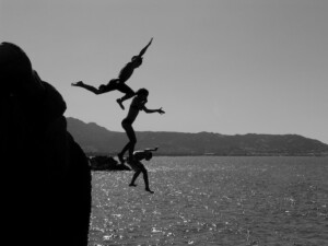 People Jumping off a Cliff into the Water