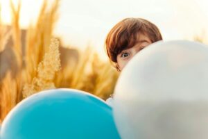A kid peaking Out from Balloons